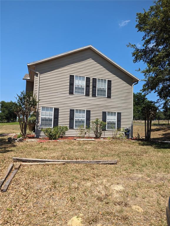 The exterior of a two-story house with beige siding and dark shutters — 20333 SUGARLOAF MOUNTAIN ROAD, CLERMONT, FL