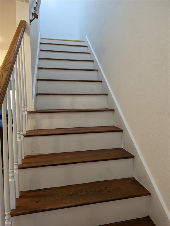 A staircase with wooden treads and white risers features a white railing and handrail — 20333 SUGARLOAF MOUNTAIN ROAD, CLERMONT, FL