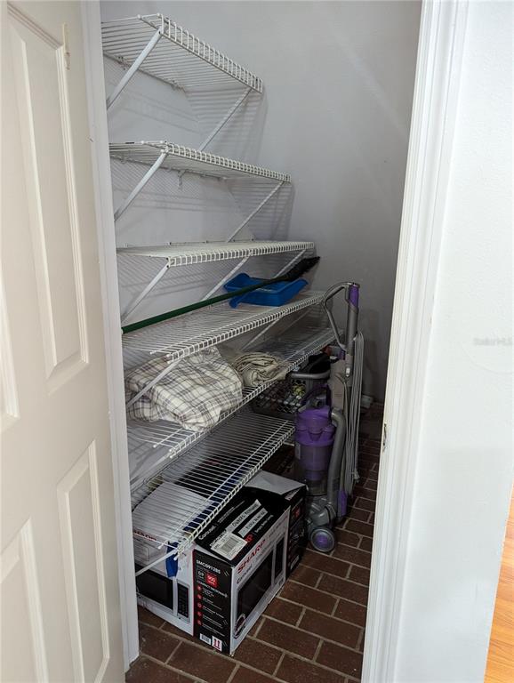 A closet with wire shelving, a vacuum cleaner, and a boxed microwave on the floor — 20333 SUGARLOAF MOUNTAIN ROAD, CLERMONT, FL