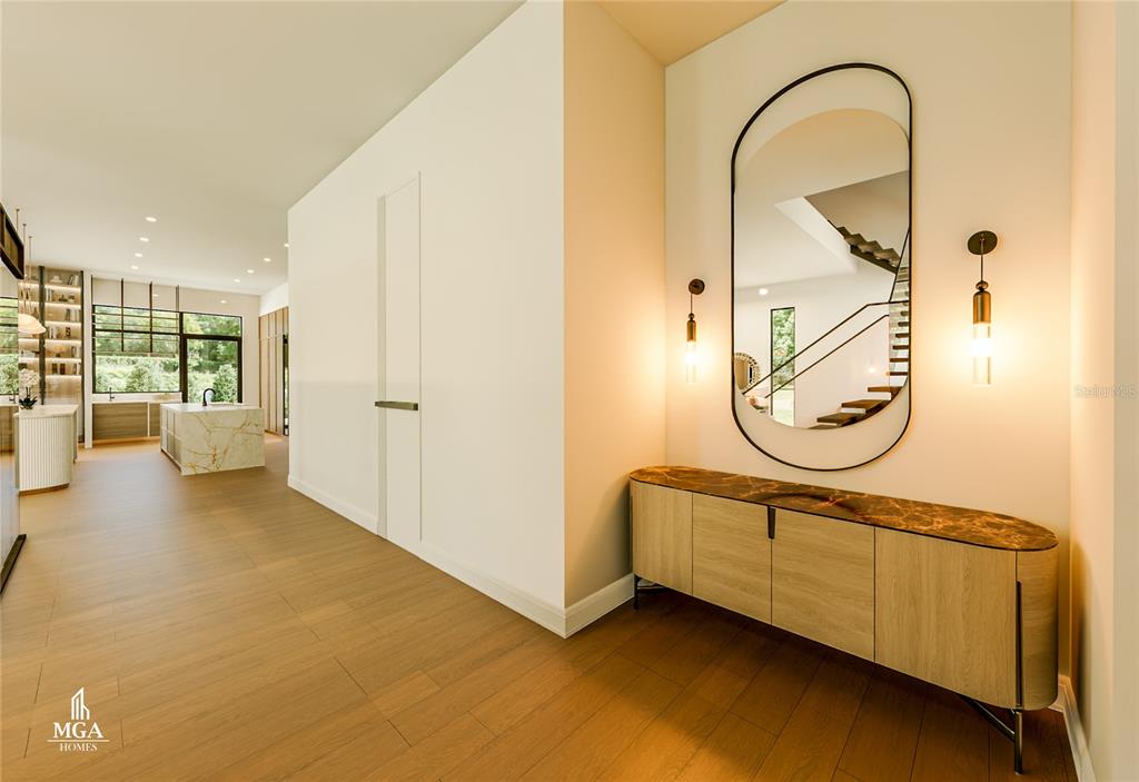 A modern entryway features a wooden console table, a tall arched mirror, and light wood flooring — 4103 W KNIGHTS AVENUE, TAMPA, FL
