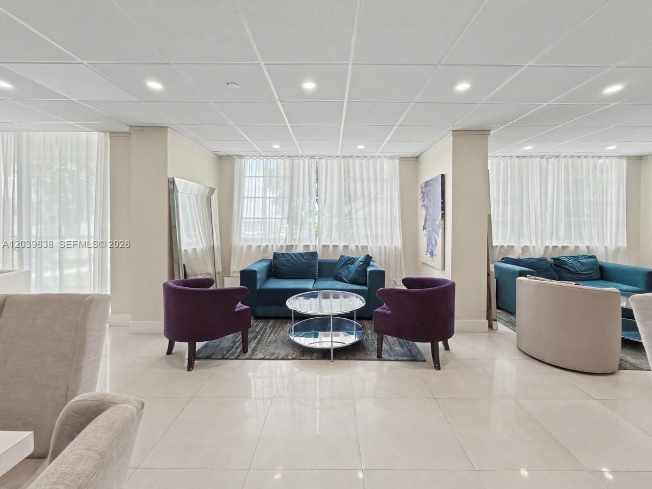 A lounge area features a blue sofa, two purple armchairs, and a glass coffee table — 3301 NE 5th Ave # 307, Miami FL 33137, MIAMI, FL