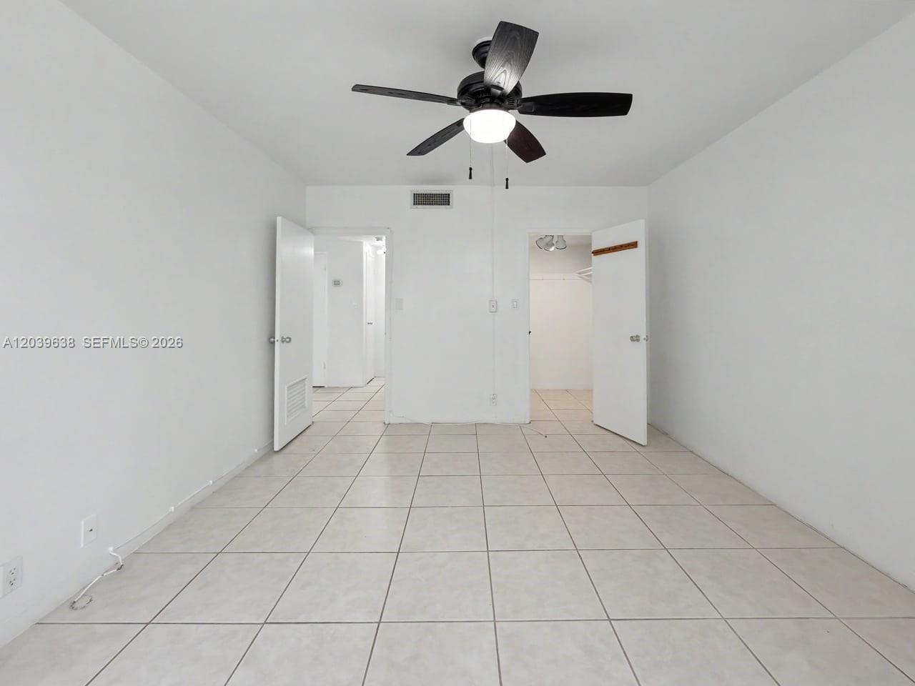 A room with white walls, tile flooring, a ceiling fan, and two open doorways — 3301 NE 5th Ave # 307, Miami FL 33137, MIAMI, FL