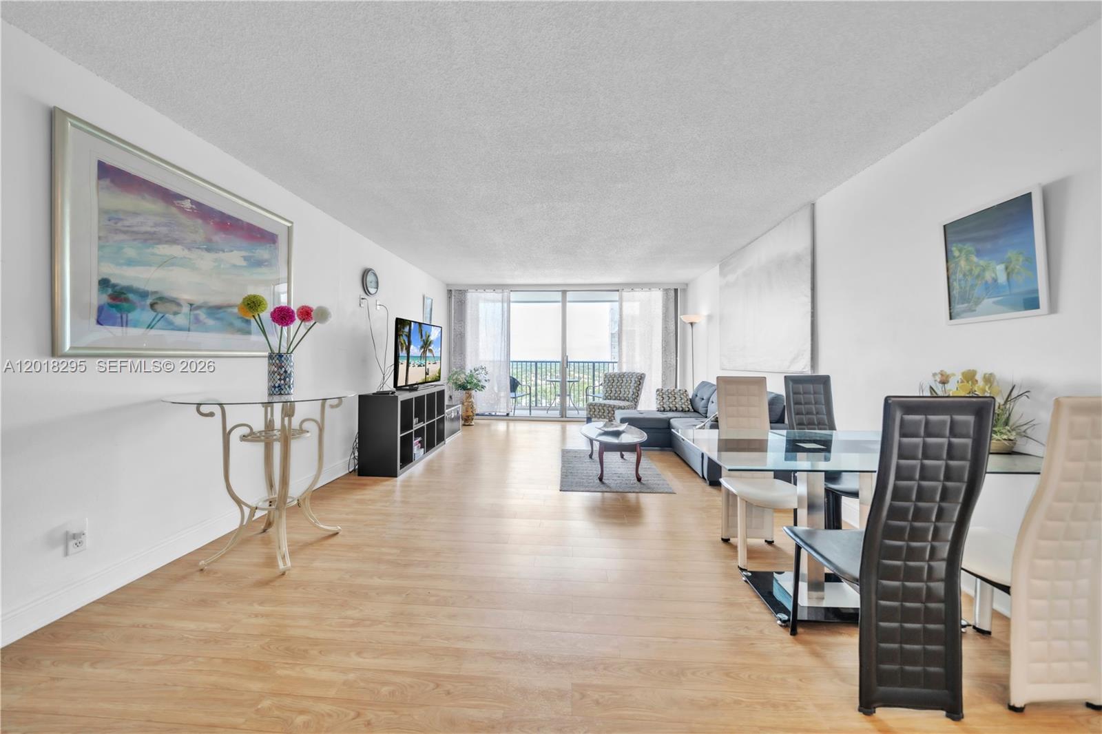 A bright, open-concept living and dining area features light wood flooring and a balcony view — 2101 S Ocean Dr, Hollywood FL 33019, HOLLYWOOD, FL