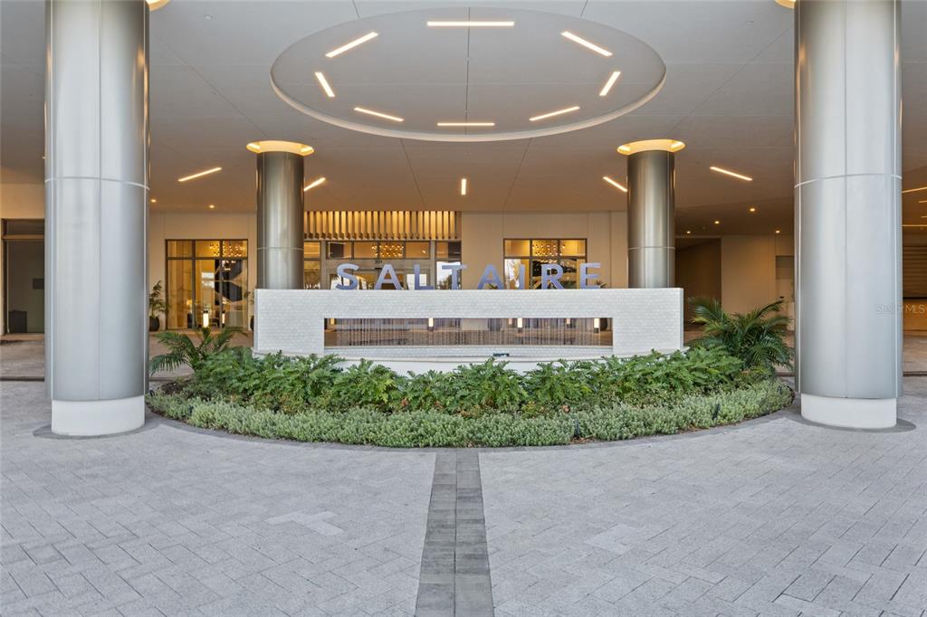 The exterior entrance of a modern building features a circular fountain and large metal columns — 301 1ST STREET S UNIT 2705, ST PETERSBURG, FL