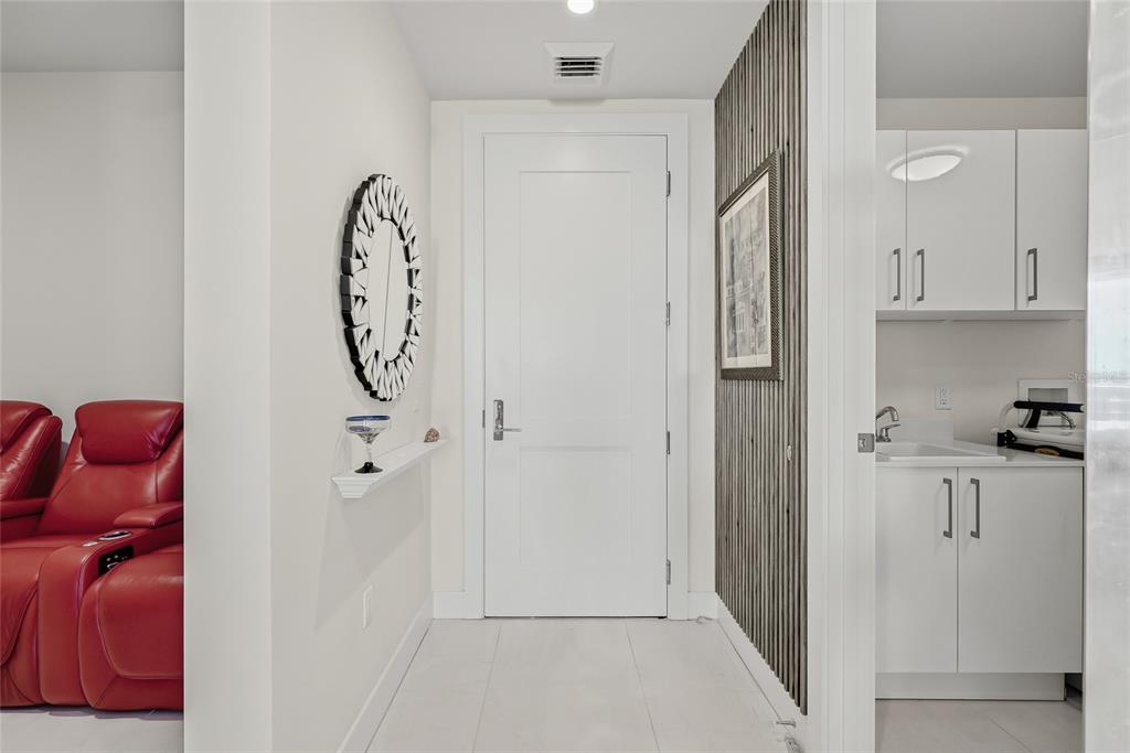 A hallway features a white door, a decorative mirror, and a small wet bar area — 301 1ST STREET S UNIT 2705, ST PETERSBURG, FL