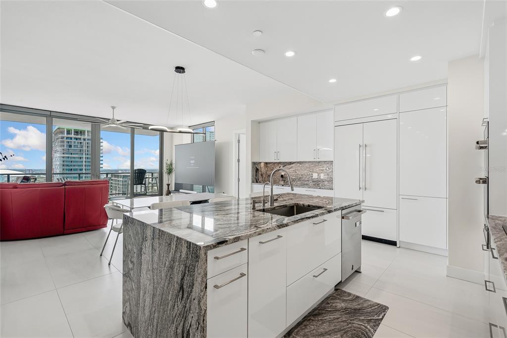 A modern kitchen with a stone waterfall island, white cabinetry, and a view of city buildings — 301 1ST STREET S UNIT 2705, ST PETERSBURG, FL