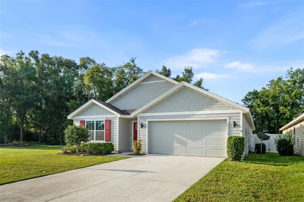A single-story house with light gray siding, a two-car garage, and red window shutters — 25119 NW 8TH ROAD, NEWBERRY, FL