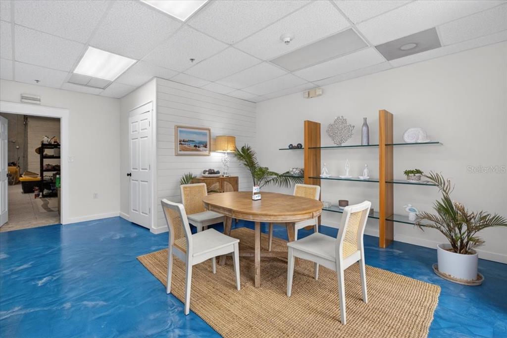 A dining area features a wooden table, four chairs, a jute rug, and blue flooring — 6321 PORTER UNIT 3, SARASOTA, FL