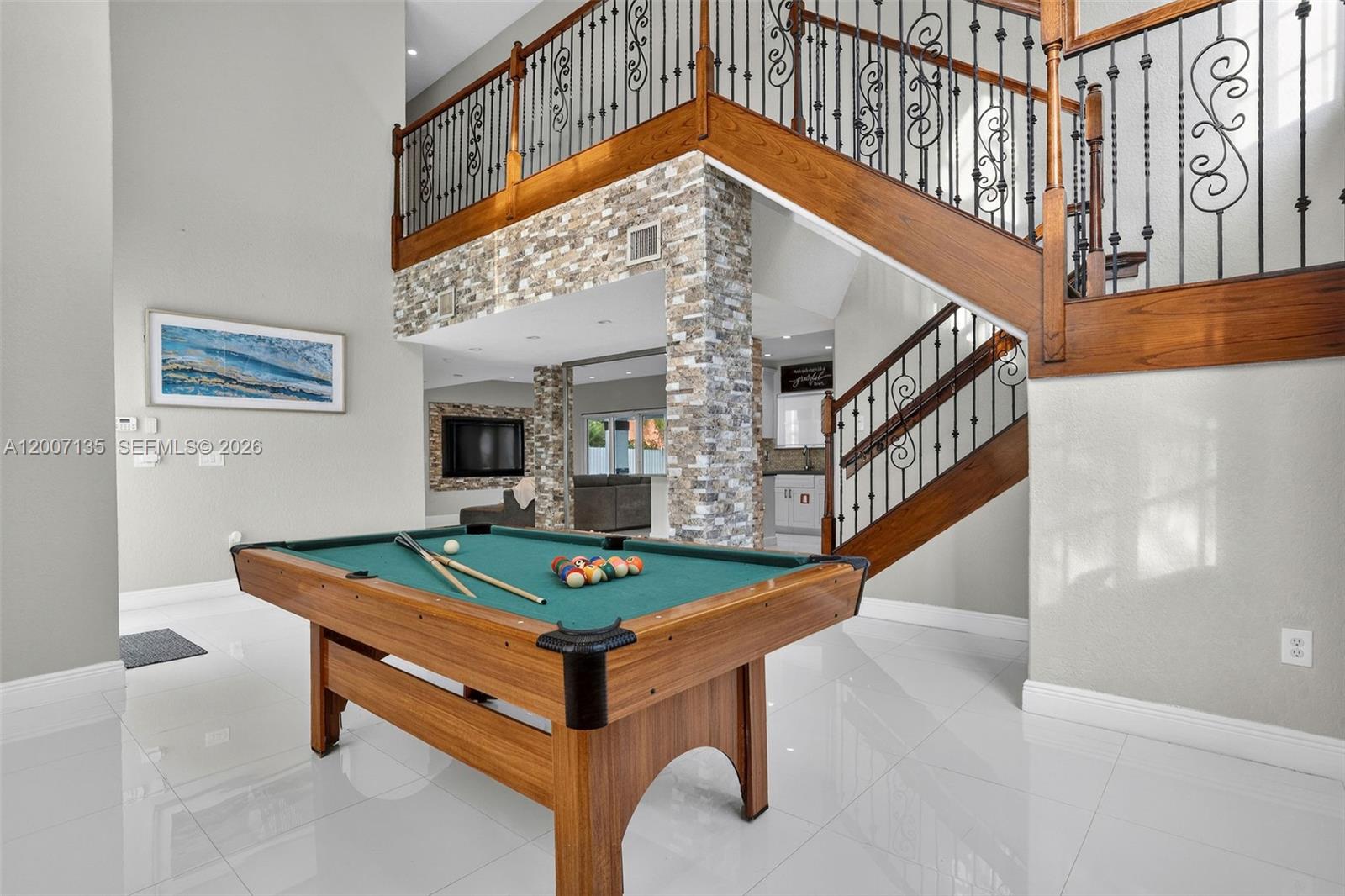 A pool table sits in a room with a stone-accented wall and a wooden staircase — 5161 SW 159th Ct, Miami FL 33185, MIAMI, FL