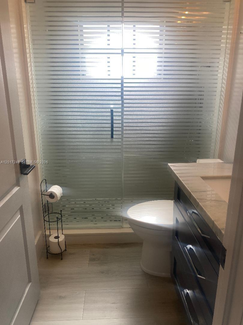 A bathroom features a glass-enclosed shower, a white toilet, and a dark wood vanity — 14640 SW 180th St, Miami FL 33177, MIAMI, FL