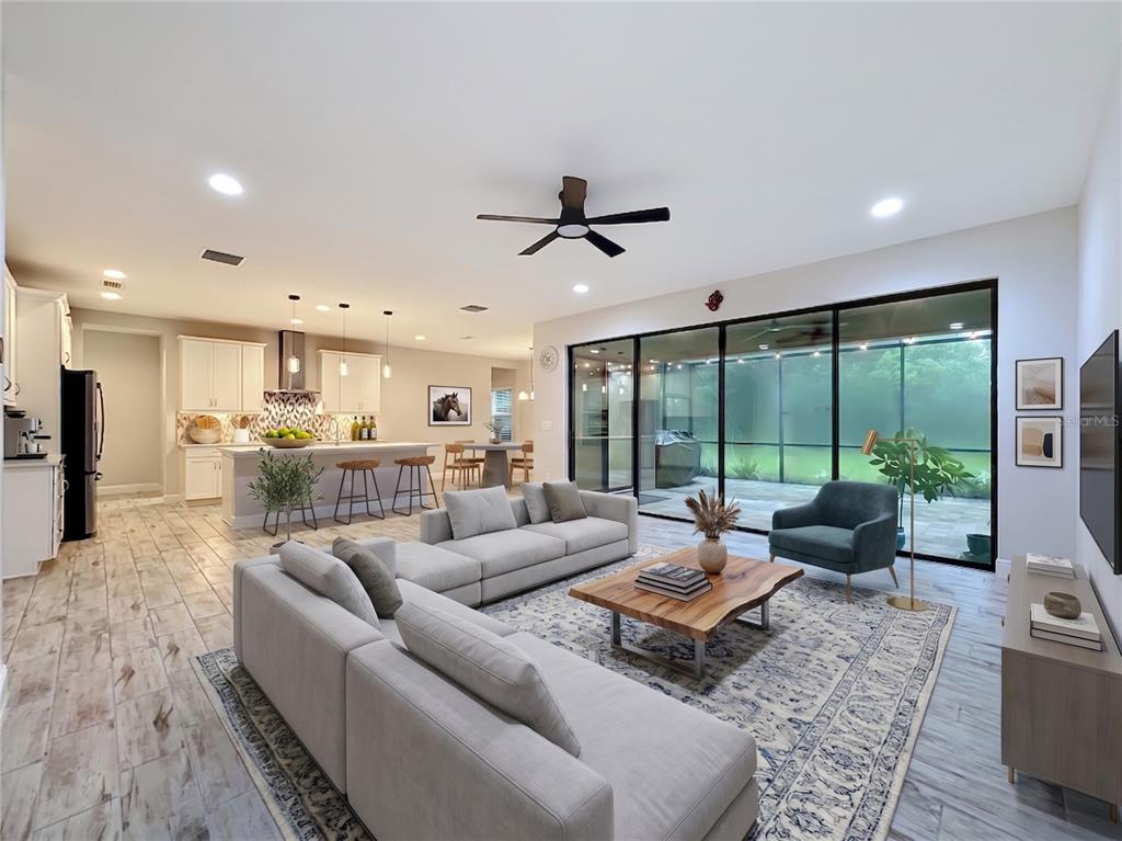An open-concept living room and kitchen featuring light wood-look tile floors and sliding glass doors — 14654 HORSE TROT ROAD, LITHIA, FL