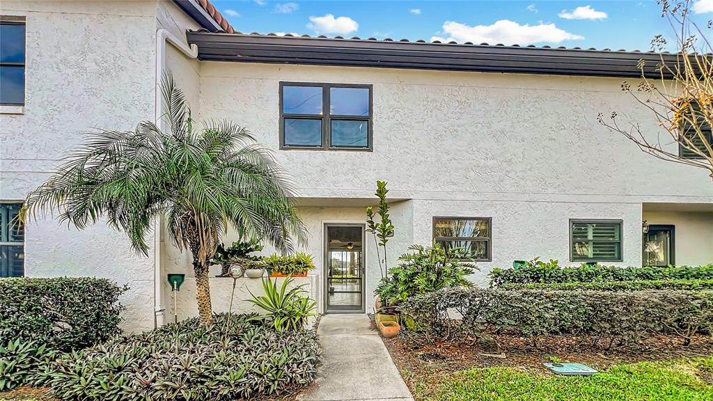 A two-story white stucco building features a palm tree, a walkway, and landscaped bushes — 630 KILLARNEY BAY COURT UNIT 3, WINTER PARK, FL