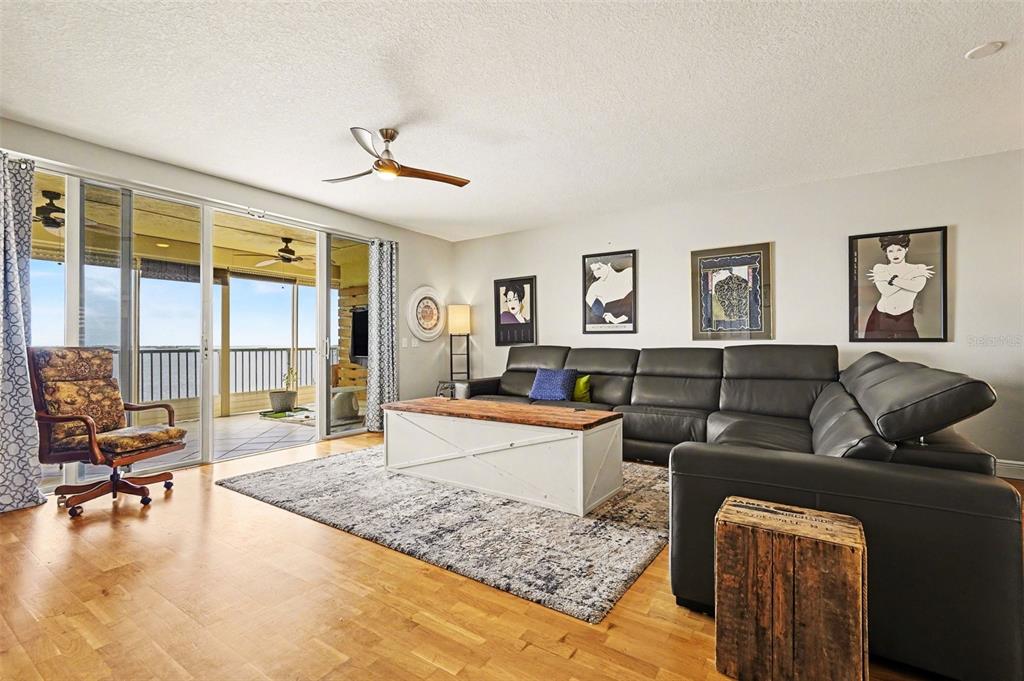 A living room with a leather sectional, coffee table, and sliding doors leading to a balcony — 104 RIVERSIDE DRIVE UNIT 602, COCOA, FL