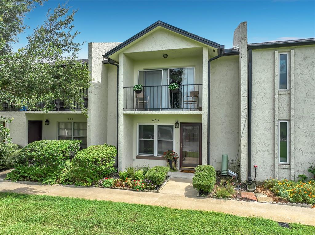 A two-story townhouse exterior with a balcony, stucco siding, and a front walkway — 603 WAVERLY LANE UNIT 405B, MAITLAND, FL