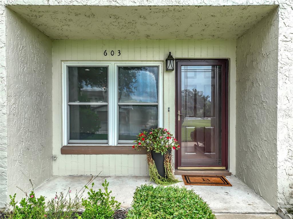 The exterior view shows a front entrance with a window, a door, and a potted plant — 603 WAVERLY LANE UNIT 405B, MAITLAND, FL
