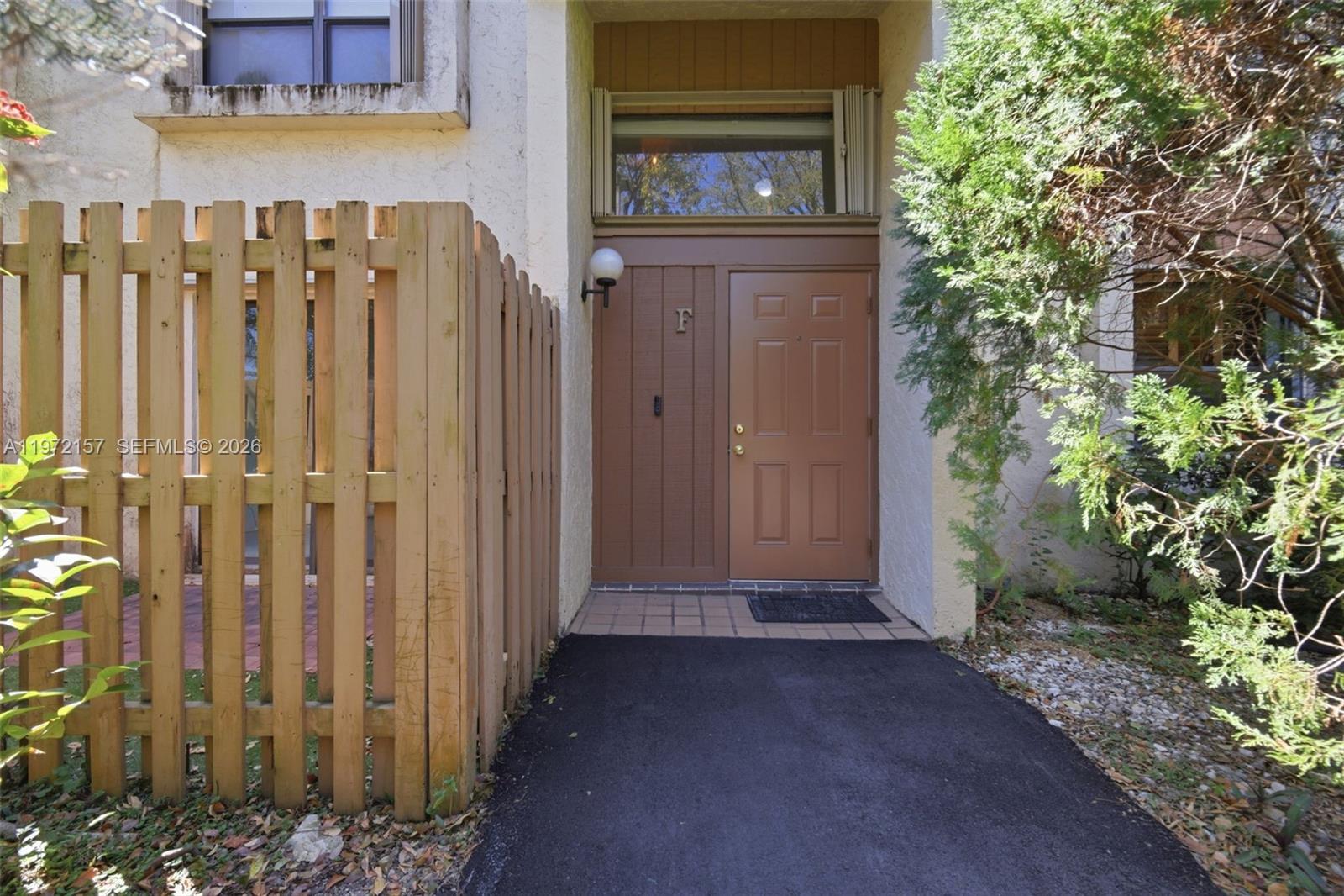 A brown front door with a transom window is accessed by a paved walkway — 11483 SW 109th Rd # 2F, Miami FL 33176, MIAMI, FL