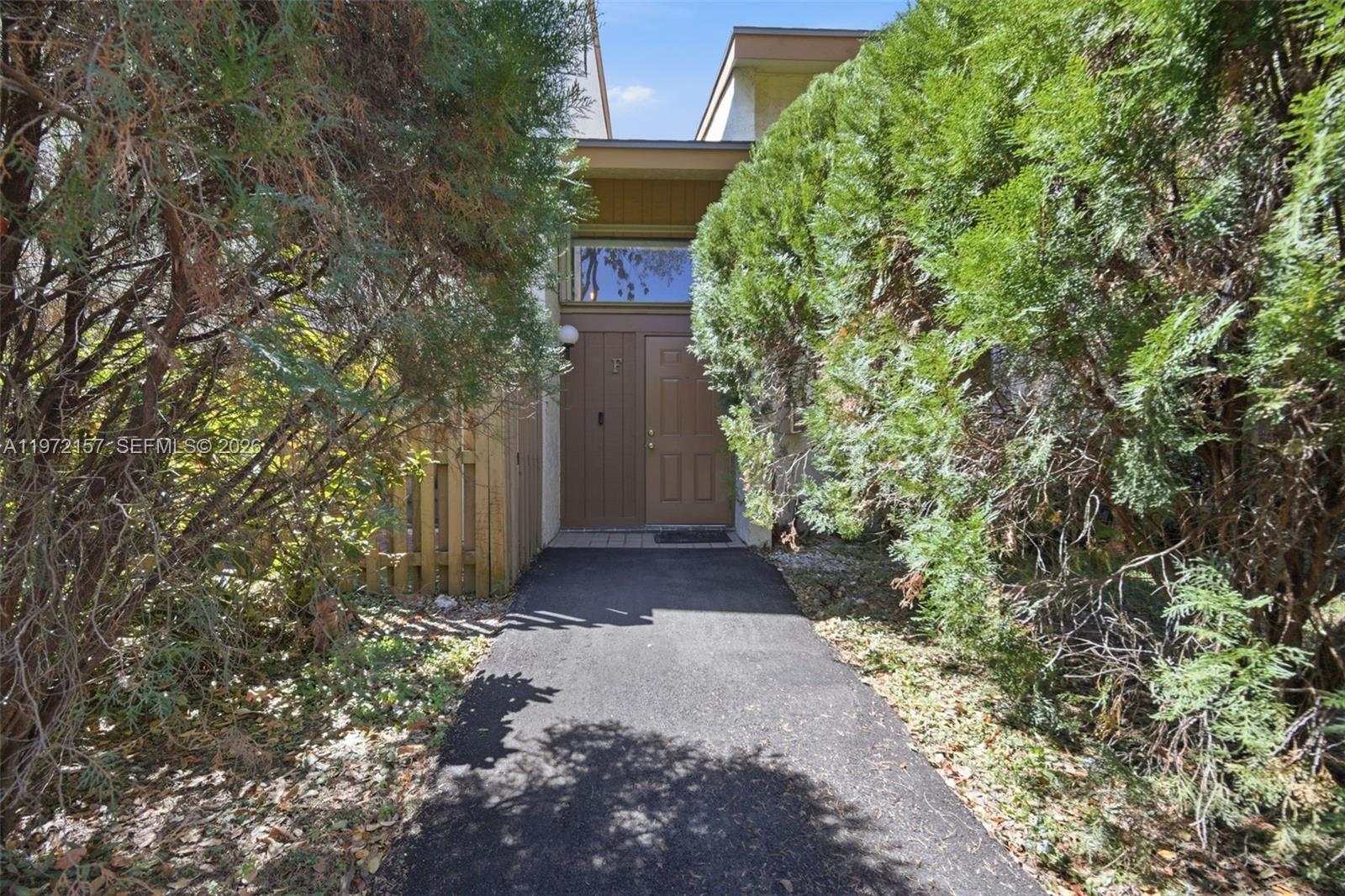 A paved walkway leads to the brown front door of a residential building — 11483 SW 109th Rd # 2F, Miami FL 33176, MIAMI, FL