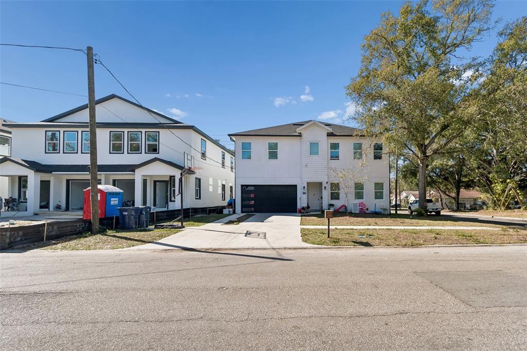Two modern two-story houses with white siding and dark trim stand side-by-side along a street — 2801 E 19TH AVENUE, TAMPA, FL