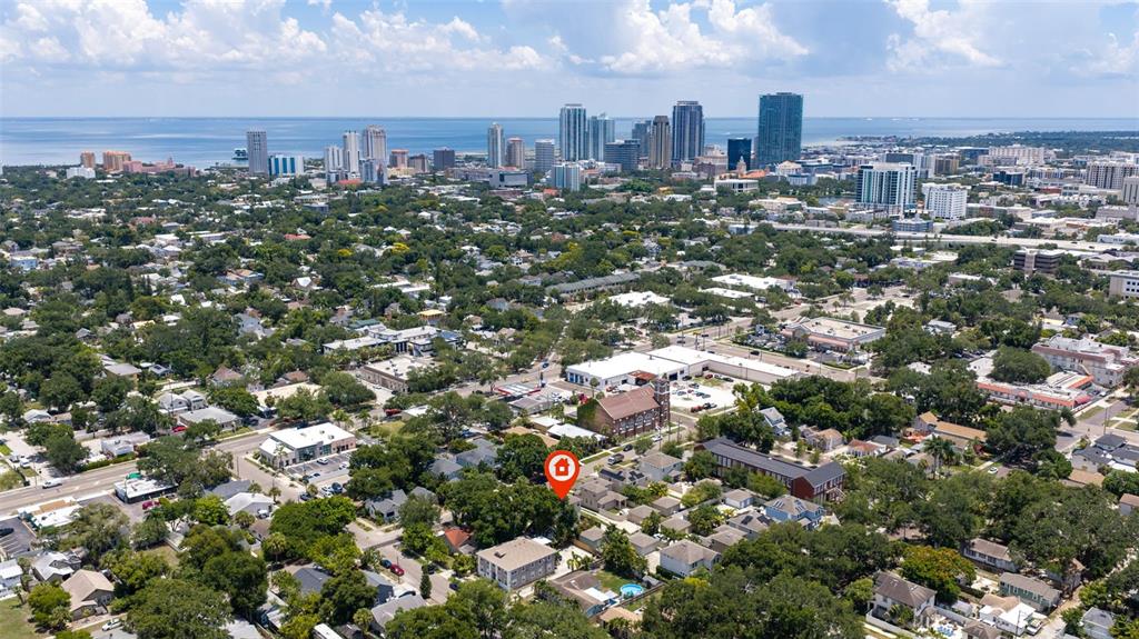 This aerial view shows a residential neighborhood with a city skyline in the background — 1110 10TH STREET N, ST PETERSBURG, FL