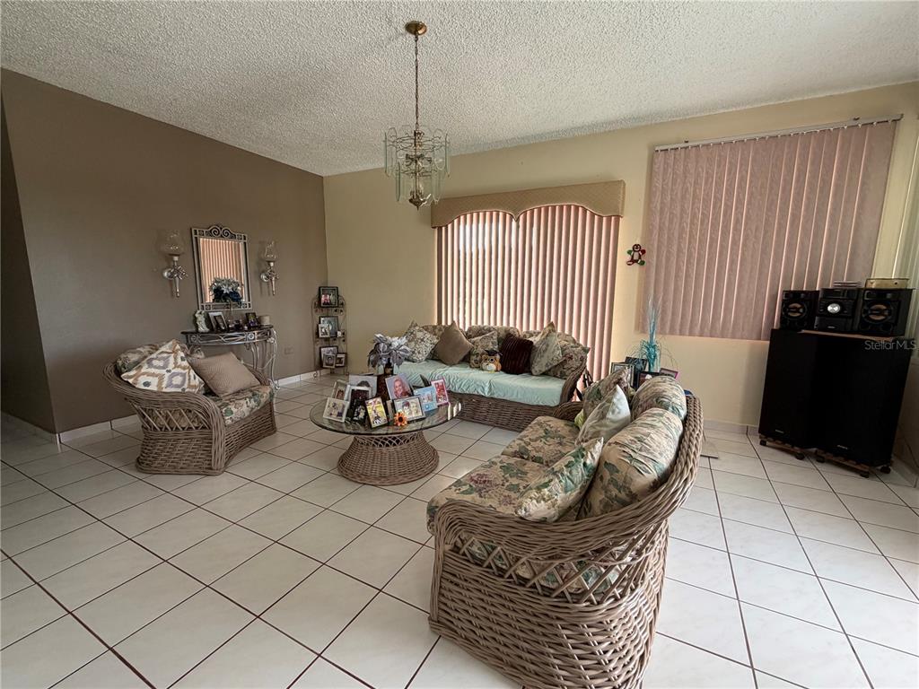 A living room features wicker furniture, a glass coffee table, and light-colored tile flooring — Sector Flor Sanchez BO. BUENA VISTA, BAYAMON, PR