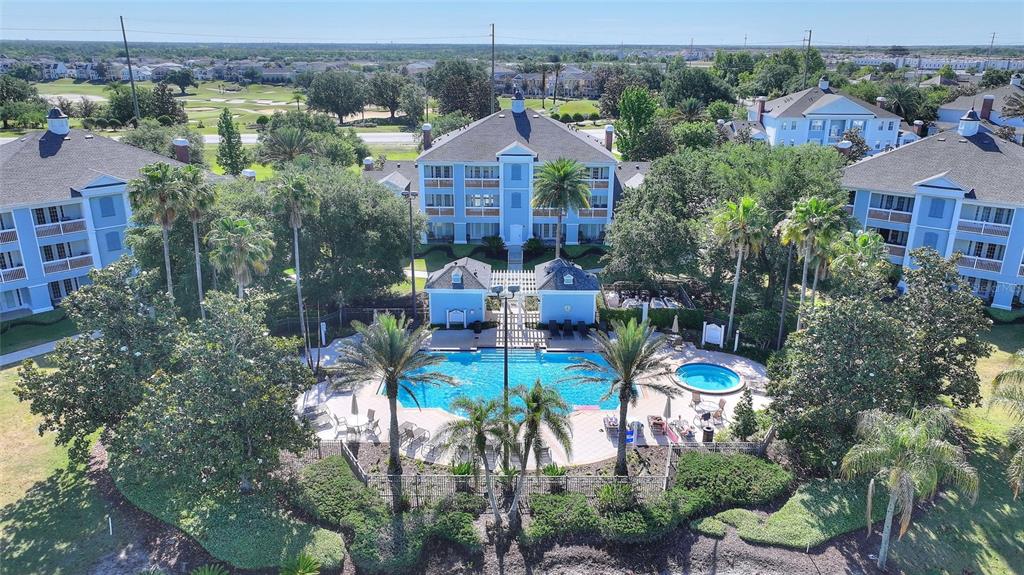 An aerial view shows a swimming pool and hot tub surrounded by multi-story apartment buildings — 1593 HERITAGE CROSSING COURT UNIT G, REUNION, FL