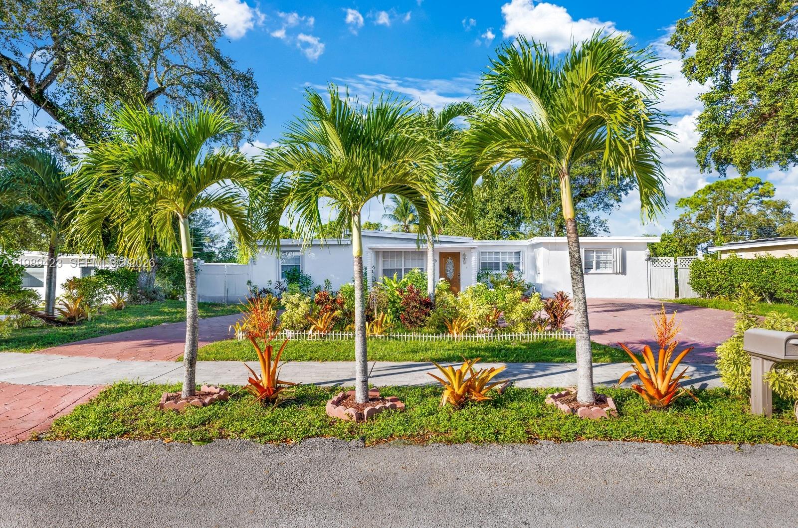 A single-story white house with a paved driveway and palm trees in the front yard — 38 Miami Gardens Rd, West Park FL 33023, WEST PARK, FL