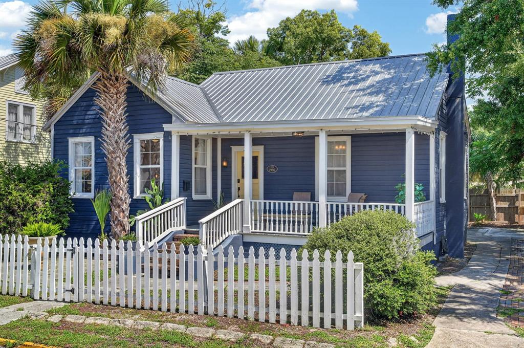 A blue cottage with a metal roof, a front porch, and a white picket fence — 28 JOINER STREET, ST AUGUSTINE, FL