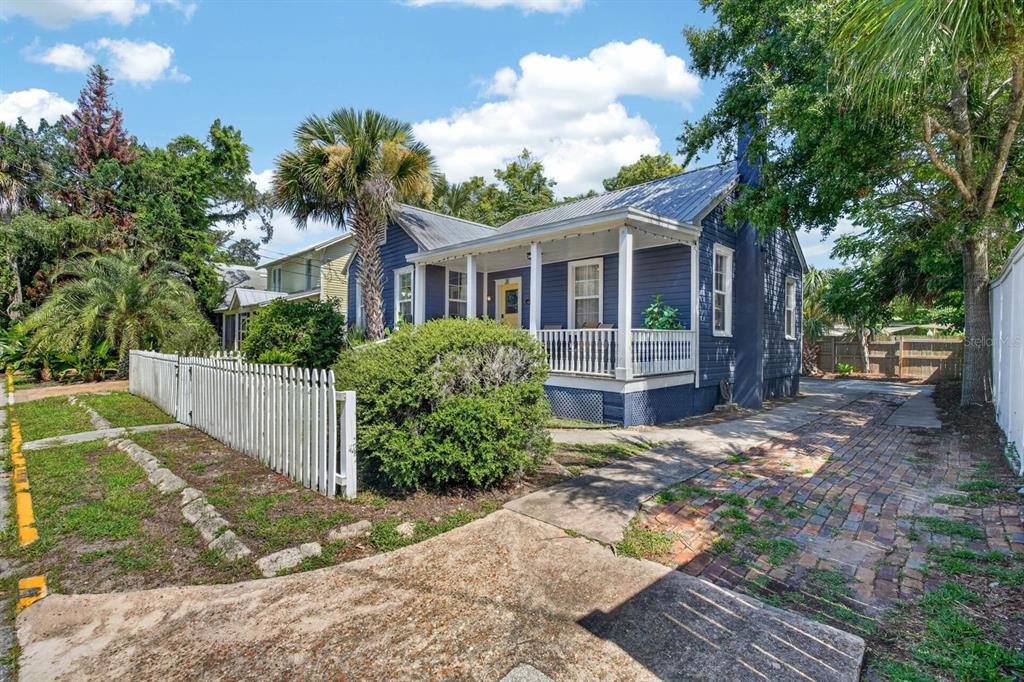 A blue house with a metal roof and a white picket fence sits on a lot — 28 JOINER STREET, ST AUGUSTINE, FL