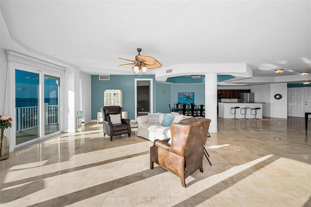 A spacious living area with tile floors, a ceiling fan, and a view of water — 1860 N FORT HARRISON AVENUE UNIT 103, CLEARWATER, FL