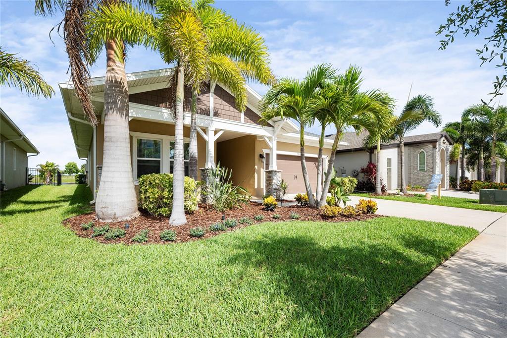 A single-story house with a tan exterior, palm trees, and a front-facing garage — 5830 SILVER SUN DRIVE, APOLLO BEACH, FL