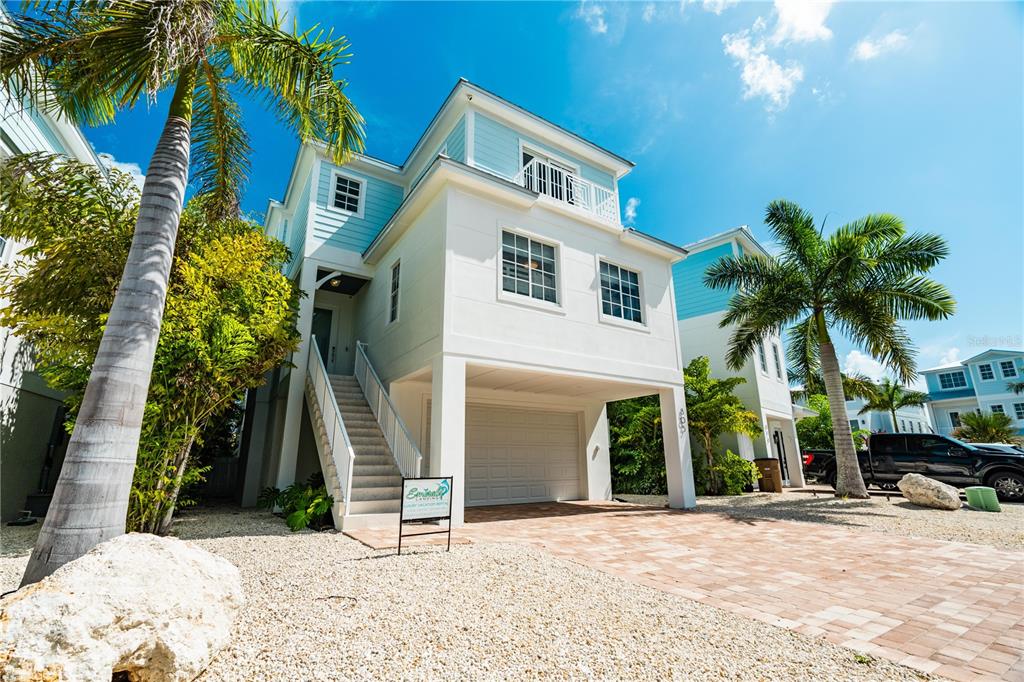 A three-story white house with balconies, a patio, and a swimming pool in the yard — 805 39TH STREET GULF, MARATHON, FL