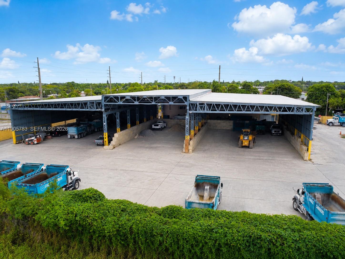 An aerial view shows a large industrial warehouse with open bays and parked dump trucks — 8600 NW 36th Ave, Miami FL 33147, MIAMI, FL