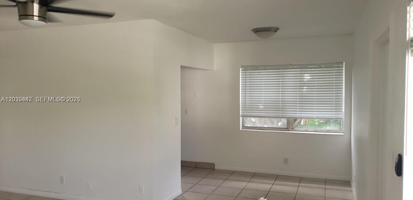 A room with white walls, tiled flooring, a ceiling fan, and a window with blinds — 320 Fanshaw H # 320, Boca Raton FL 33434, BOCA RATON, FL