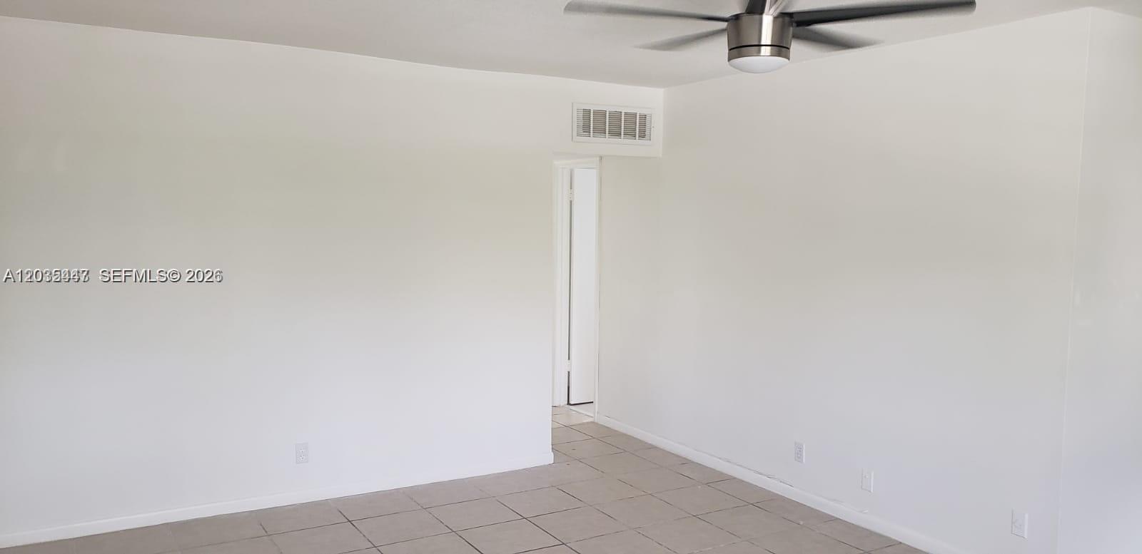 A room with white walls, tiled flooring, a ceiling fan, and a doorway leading elsewhere — 320 Fanshaw H # 320, Boca Raton FL 33434, BOCA RATON, FL