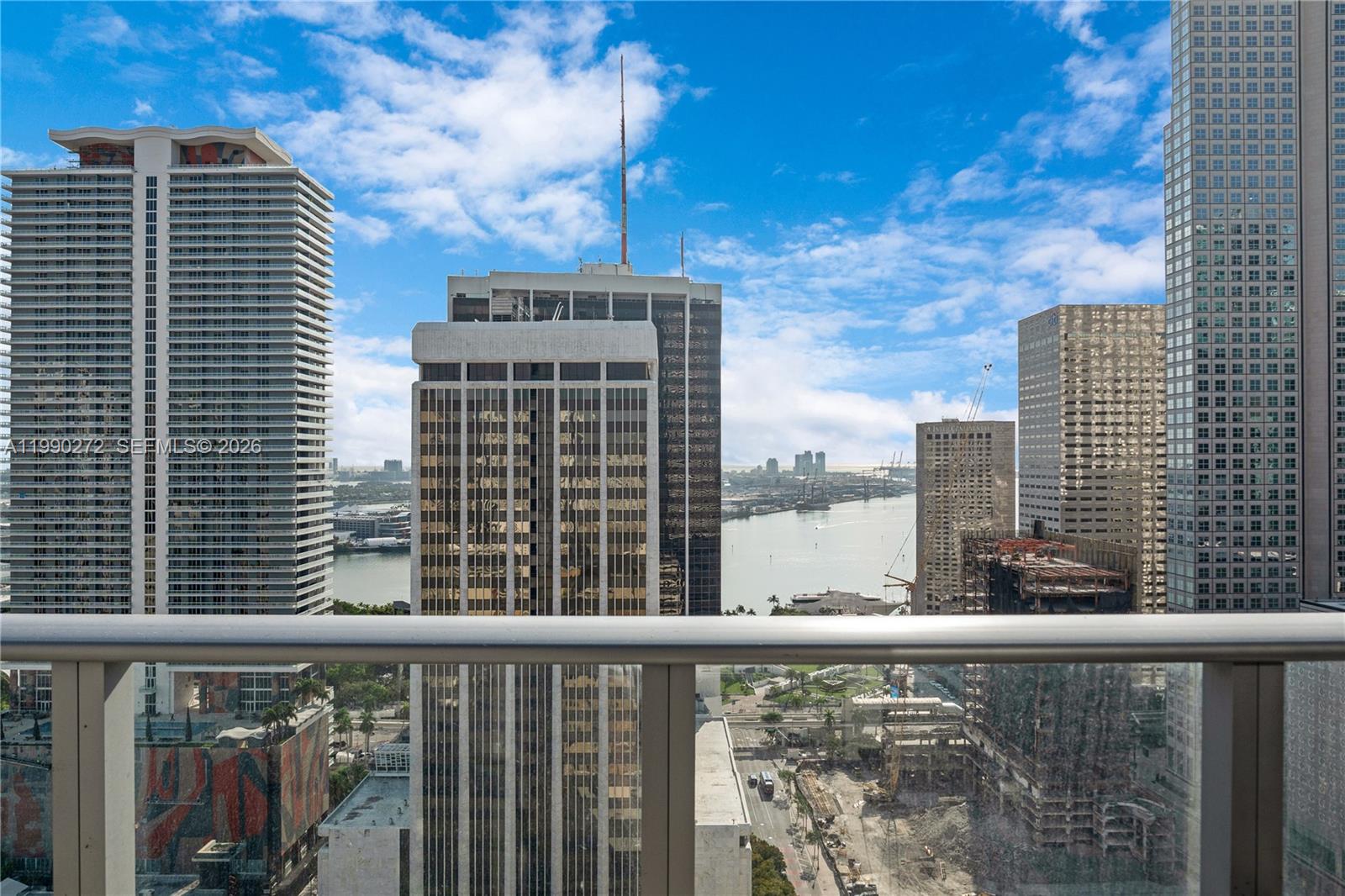 A balcony view overlooking a city skyline, a river, and several high-rise buildings — 151 SE 1st St # 2802, Miami FL 33131, MIAMI, FL