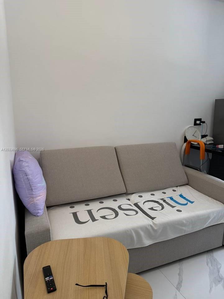 A light-colored sofa with a branded throw blanket sits in a room with white walls — 1 Cana Rock # 215, FL