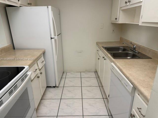 A kitchen features white cabinets, a white refrigerator, a double sink, and tiled flooring — 14221 N Kendall Dr # 211C, Miami FL 33186, MIAMI, FL
