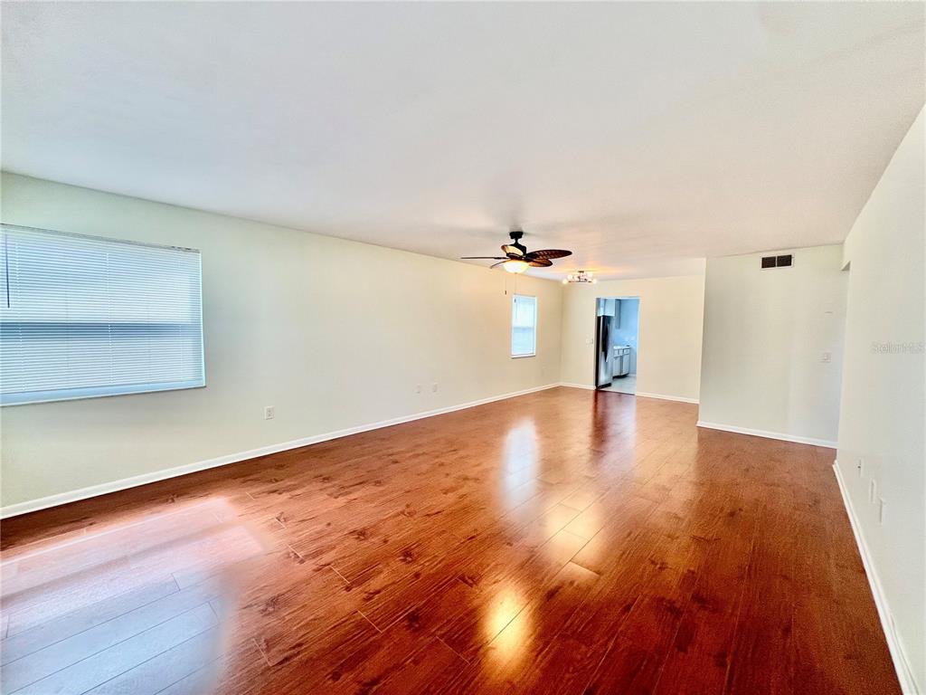 A spacious living room features light-colored walls, a ceiling fan, and dark wood-look flooring — 5920 18TH STREET N UNIT 14, ST PETERSBURG, FL