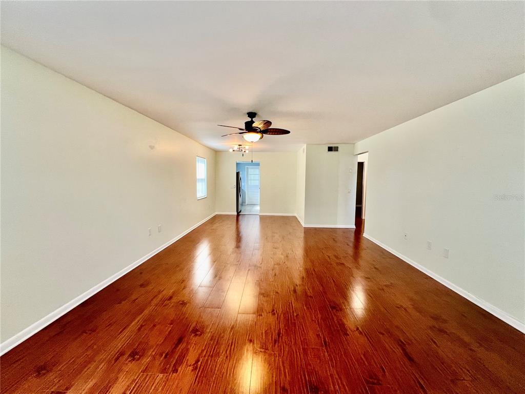 A spacious living room features light-colored walls, a ceiling fan, and dark wood flooring — 5920 18TH STREET N UNIT 14, ST PETERSBURG, FL
