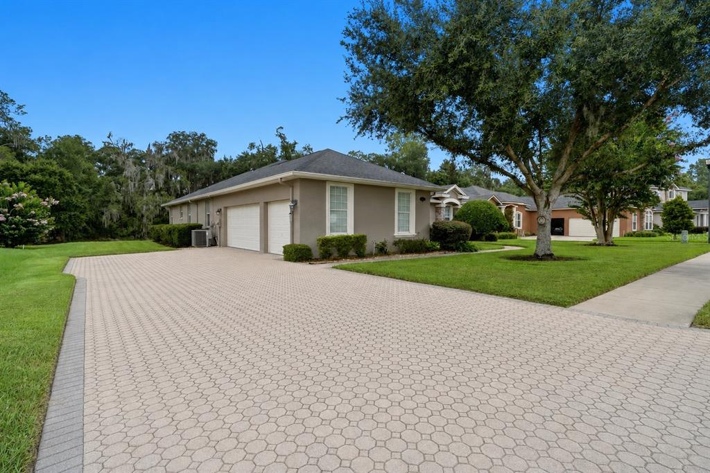 A tan house with a two-car garage and a large paved driveway — 3196 HAWKS RIDGE DRIVE, LAKELAND, FL