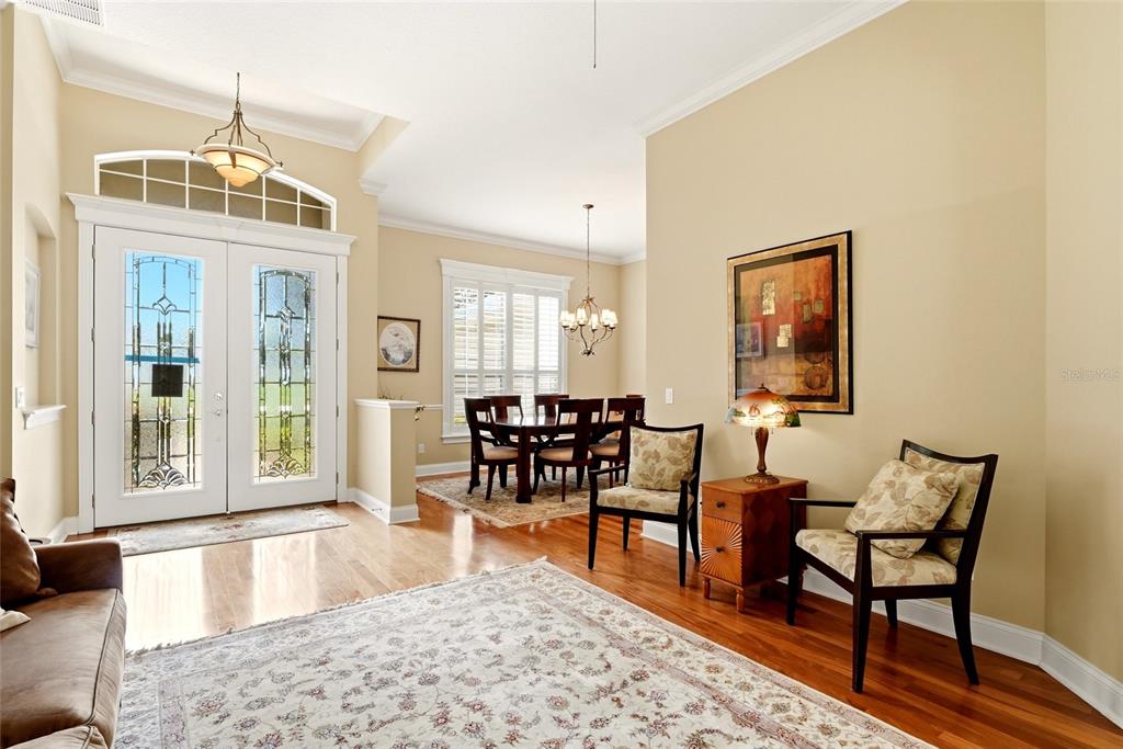 A living room with hardwood floors, a large area rug, and an adjacent dining area — 3196 HAWKS RIDGE DRIVE, LAKELAND, FL