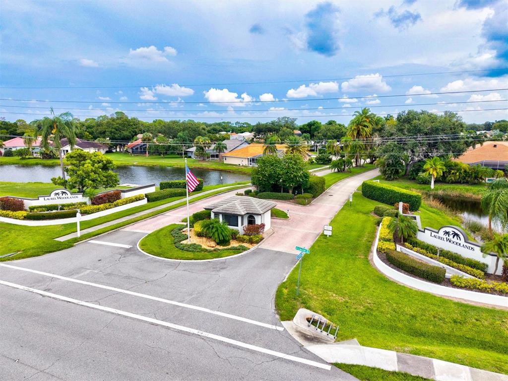An aerial view of the gated entrance to the Laurel Woodlands community with a pond — 1059 TRUMAN STREET, NOKOMIS, FL