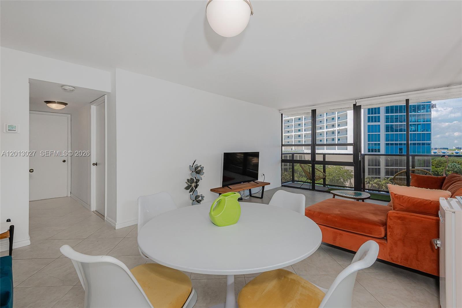 A dining area with a round table and chairs sits adjacent to a living space — 600 NE 36th St # 706, Miami FL 33137, MIAMI, FL