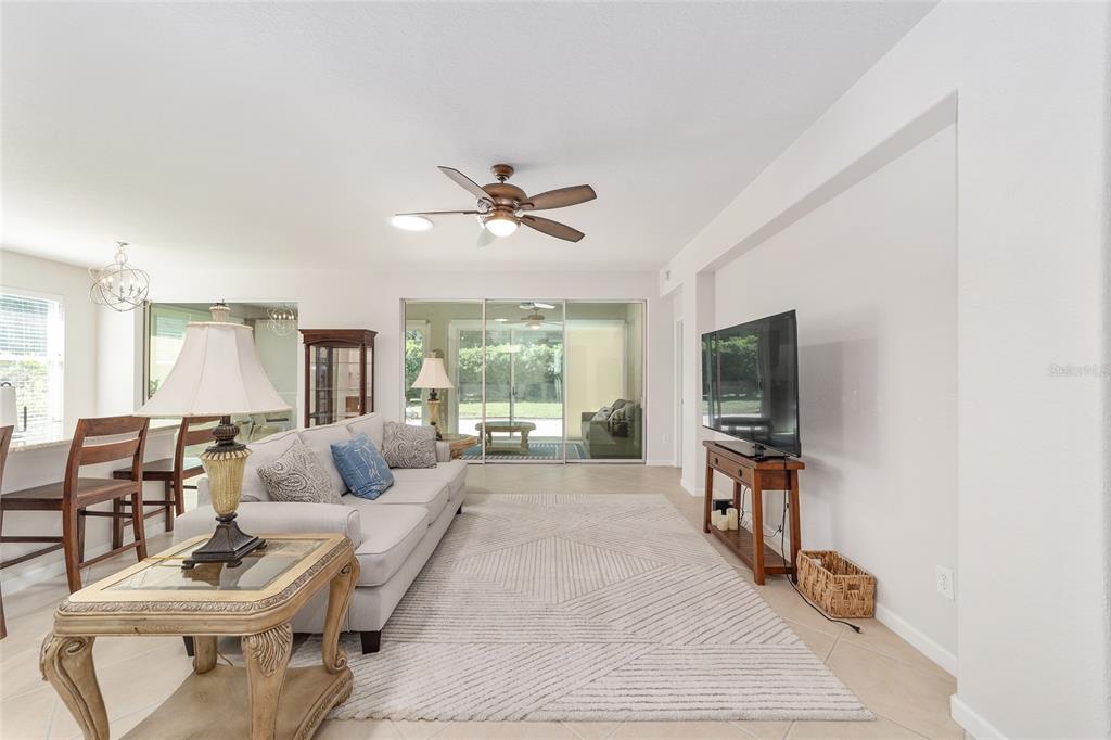 A living room with a sofa, area rug, television, and sliding glass doors to a patio — 9395 SW 66TH LOOP, OCALA, FL
