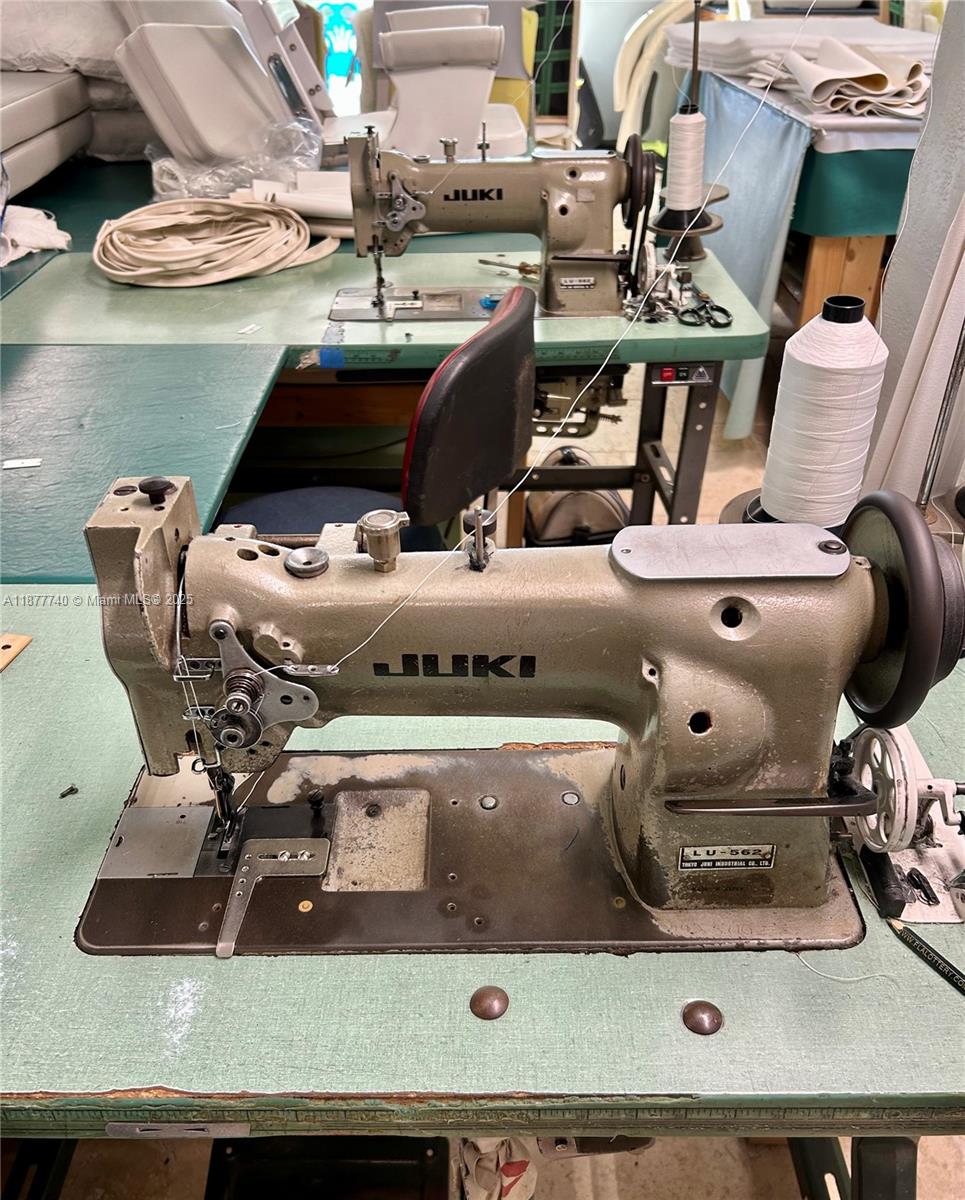 Two industrial Juki sewing machines sit on a green work table in a workshop — 108 Madeira Rd, Islamorada FL 33036, ISLAMORADA, FL