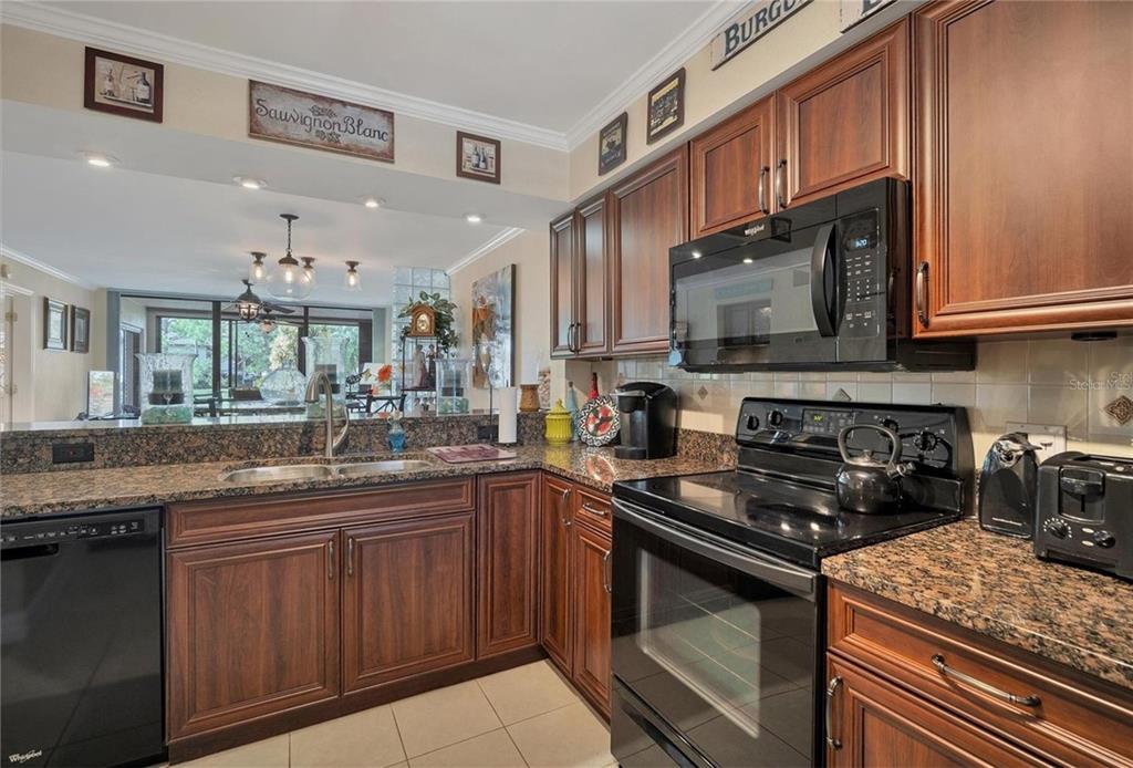 A two-story apartment building with a tiled roof and a parking lot in front — 5231 LAKE VILLAGE DRIVE UNIT 27, SARASOTA, FL