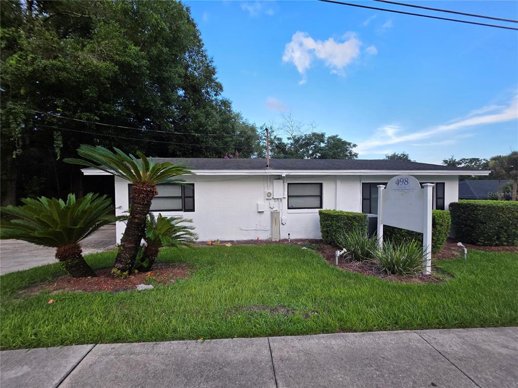 A white, single-story building with a flat roof and a prominent sign in the yard — 498 ESTHER LANE, ALTAMONTE SPRINGS, FL