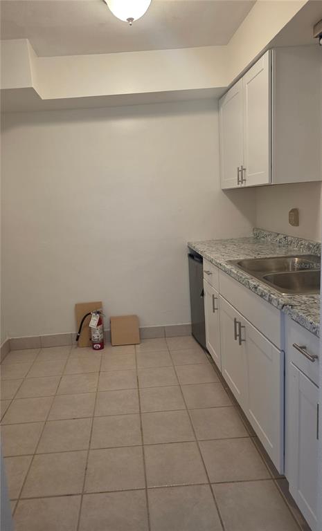 A small kitchen features white cabinets, a granite countertop, a sink, and tiled flooring — 498 ESTHER LANE, ALTAMONTE SPRINGS, FL