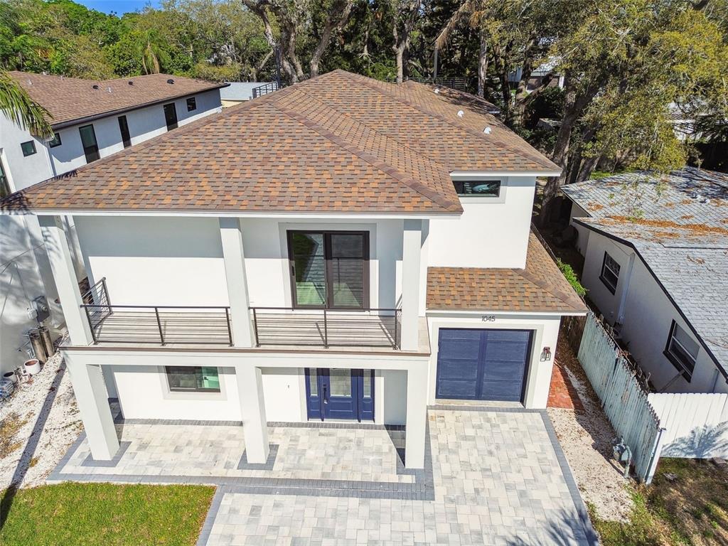 An aerial view of a two-story modern house with a paved driveway and balcony — 1045 JESSE AVENUE, SAFETY HARBOR, FL