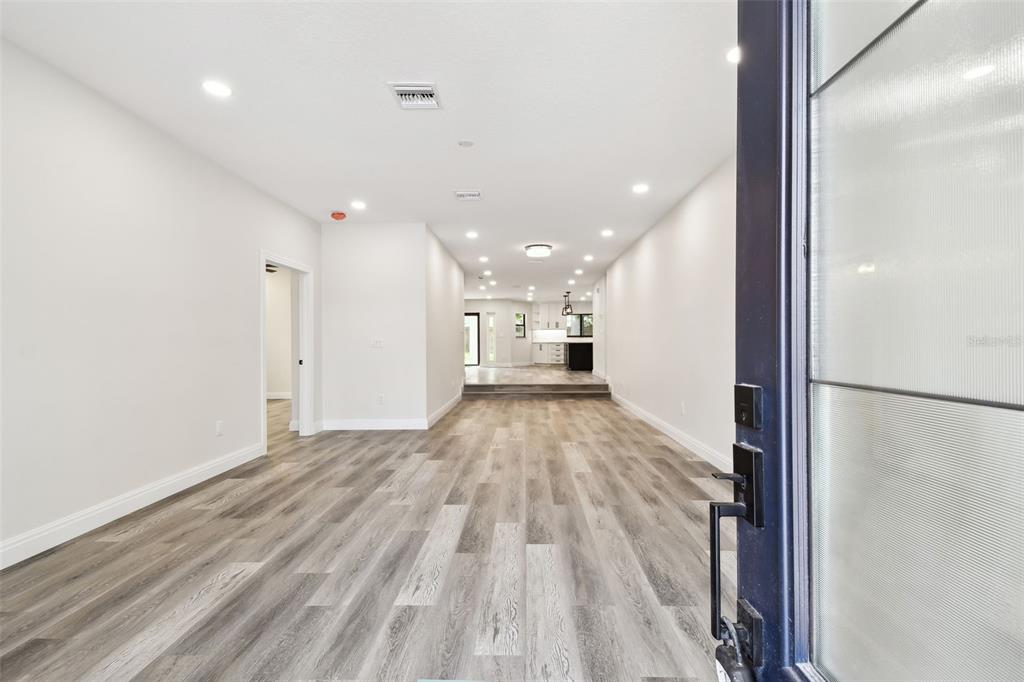 A view from an open doorway into a living area with light wood-look flooring — 1045 JESSE AVENUE, SAFETY HARBOR, FL